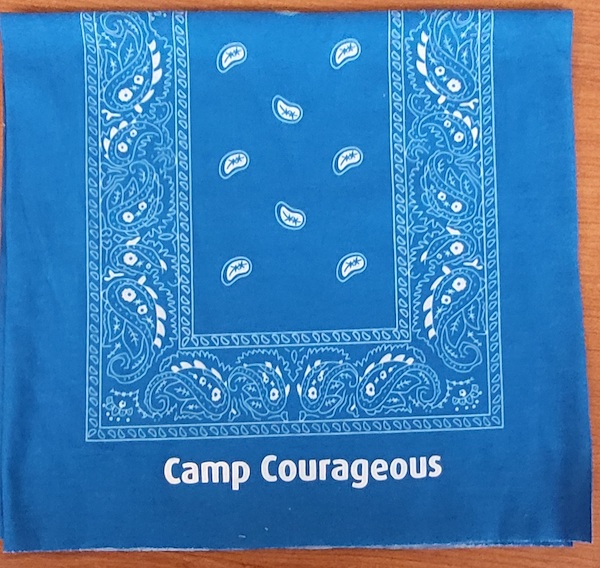 A blue stretch handkerchief print bandanna with Camp Courageous printed on the edge